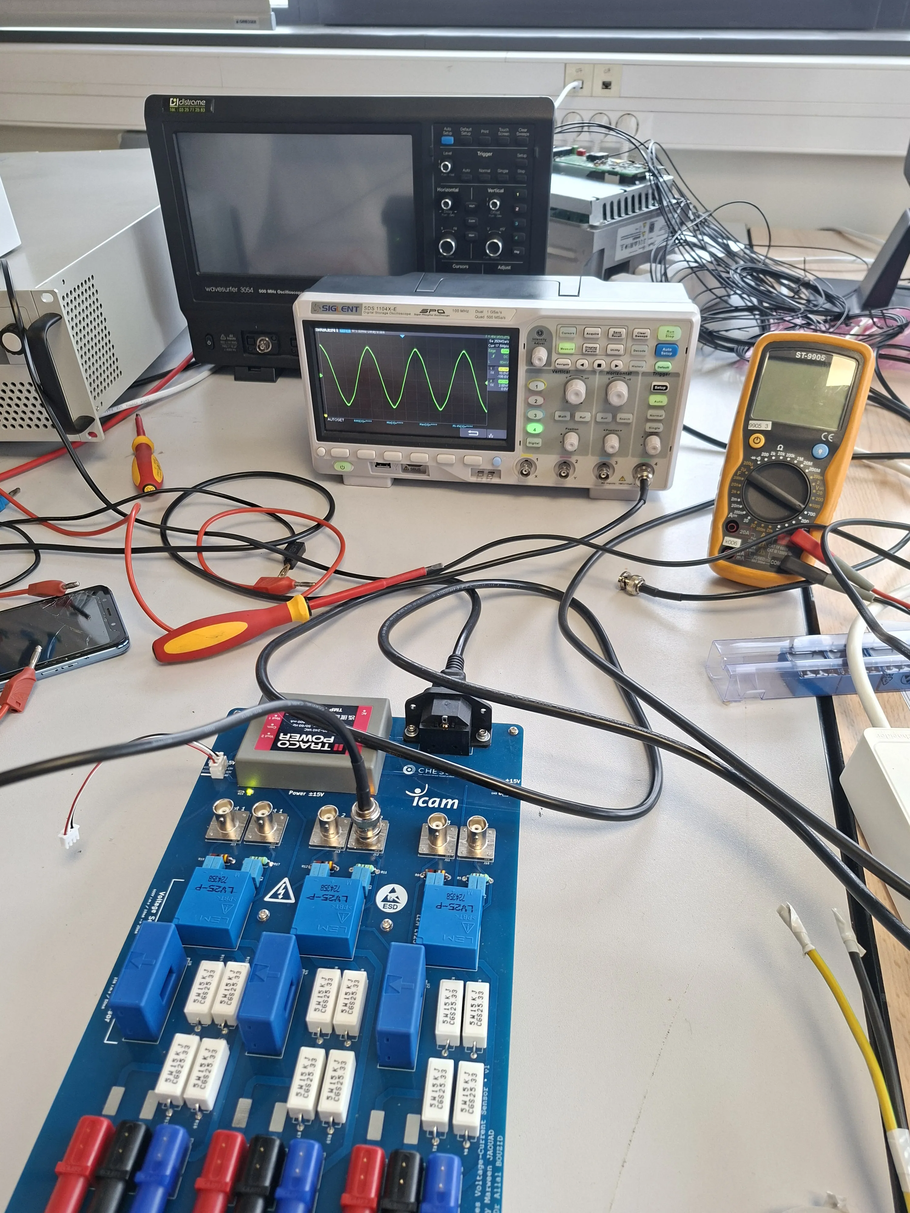Icam voltage-current sensing PCB with LV25-P transducers, TRACO ±15 V module, and a sine on the scope